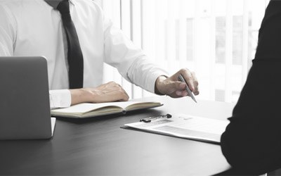 Man at desk with laptop and pad of paper